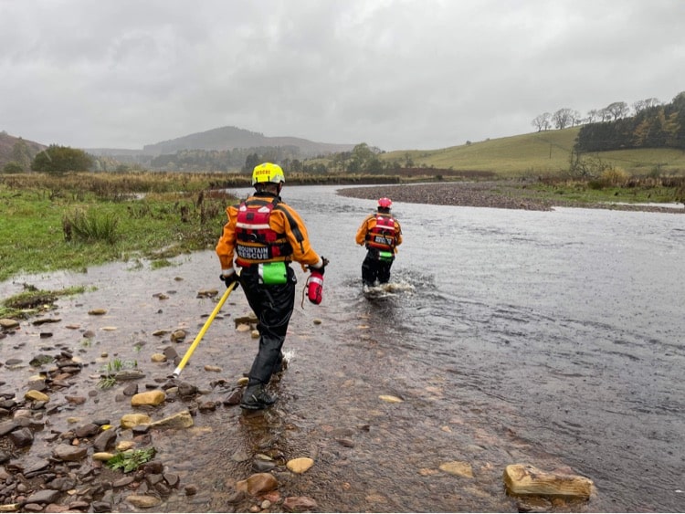 two people crossing a river